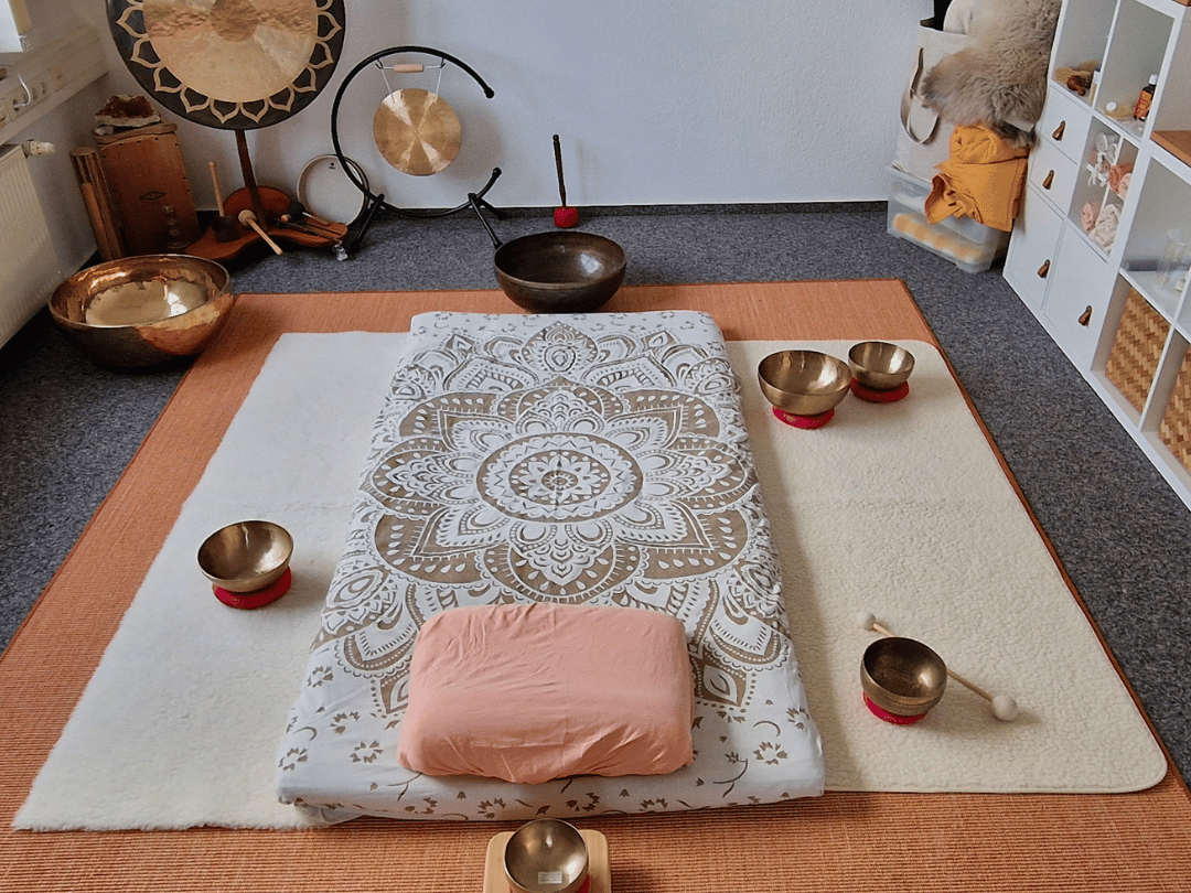 Klangmassage bei Schleiklang Meditationsbereich mit Futon, Kissen und klangvollen Schalen auf dem Boden.
